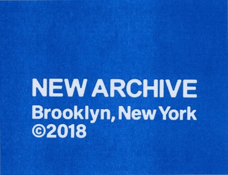 White type on blue cloth reading New Archive, Brooklyn, New York, 2018